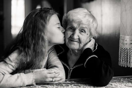 Little girl with her grandmother has a tender relationship. Black and white photo.の写真素材