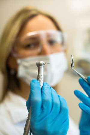 Hands female dentist doctor with dental instrument.の写真素材