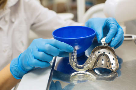Dentist hands holding removable orthodontic teeth alignment and correction trainer appliance  in...