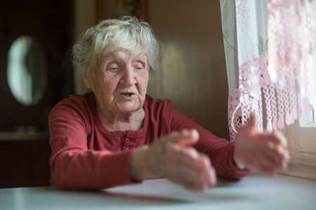 Elderly woman emotionally reacts by telling and gesturing.の写真素材