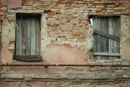 Boarded up windows of an abandoned old house.