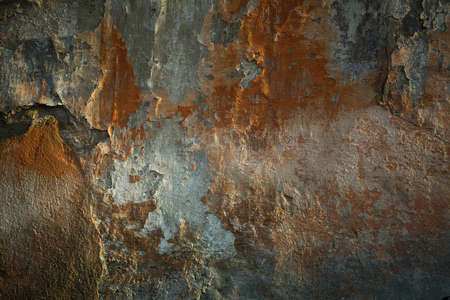 Texture of a shabby street wall with broken plaster in the sunlight.の写真素材