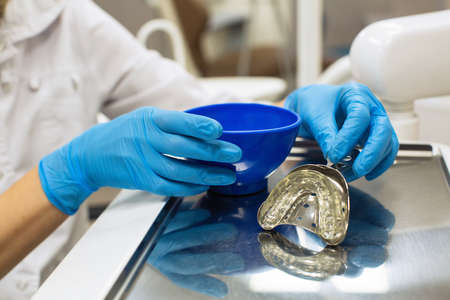 Dentist hands holding removable orthodontic teeth alignment (correction trainer appliance) in dental...