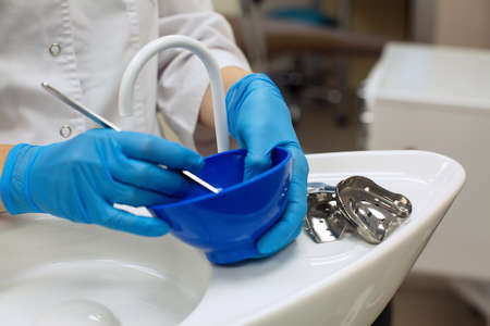Hands dentist holding detail of dental tools in dental clinic.の写真素材
