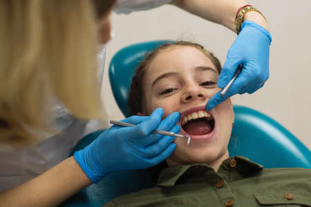 Dentist doing teeth checkup of little girl.の写真素材