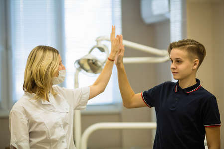 Woman dentist with a patient guy together portrait in dental room. の写真素材