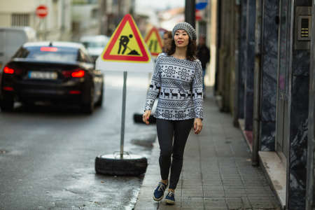 A young mixed race woman walking down the street.の写真素材