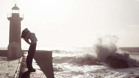 Mixed race woman in spring having fun and dancing of sea promenade. Beautiful foam surf.の写真素材