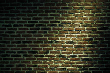 Urban texture of a brick wall with a light spot. の写真素材