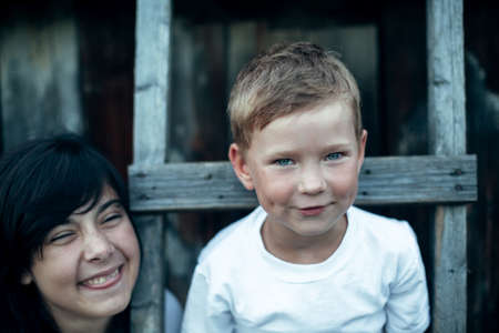 Portrait of small funny boy with sister, close-up. The village children outdoors.の写真素材