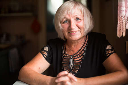 Portrait of an adult woman sitting in her house.