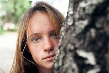 Close-up portrait of teengirl with long hair, outdoors.