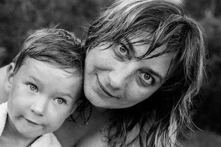 Young woman with a young son, a black-and-white portrait after a swim.の写真素材