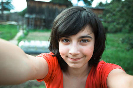 Teen girl taking a selfie out in the viilage house.