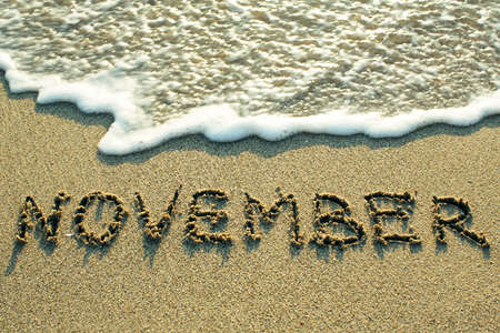 November inscription on the sand beach with the soft wave.