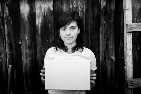 Teen girl with a white banner in the hands (space for your message) Black and white photography.の写真素材