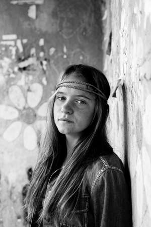 Portrait of young cute girl hippie, dirty background. Black and white photo.の写真素材