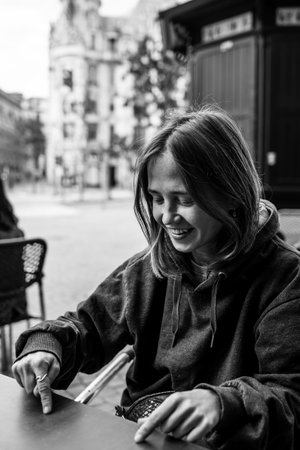 Young woman sitting at a table in a street cafe. Black and white photo.の写真素材