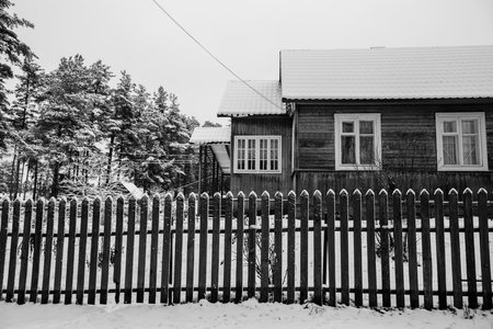 Residential buildings in snowy winter in the village in the nord of Russia. Black and white photo.の写真素材