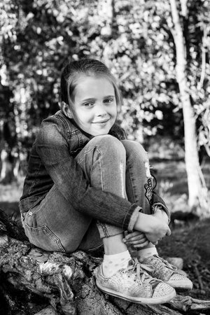 Girl sitting in the woods near birch. Black and white photo.の写真素材