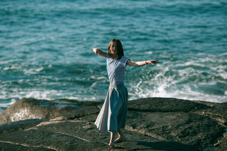 The young dancers woman is engaged in choreography on the ocean coast.の写真素材
