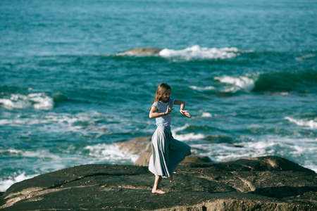 Dancer woman is engaged in choreography on the rocky Alantic coast.の写真素材
