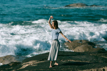 The young dancers woman is engaged in choreography on the coast of Atlantic ocean.の写真素材