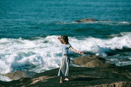 Dancer woman is engaged in choreography on the rocky Alantic coast.