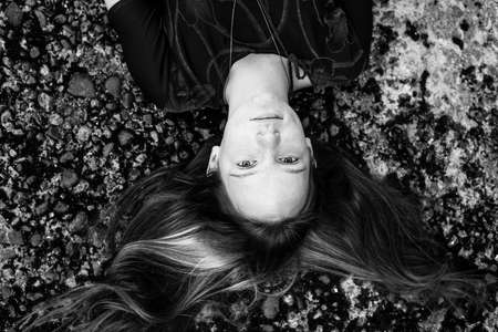 Top view portrait of a girl lying on the ground. Black and white photo.の写真素材