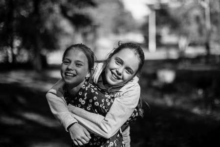 Two teen girlfriends fooling outdoors. Black and white photo.の写真素材