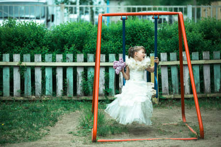 Little cute girl on the swing on the playground.の写真素材