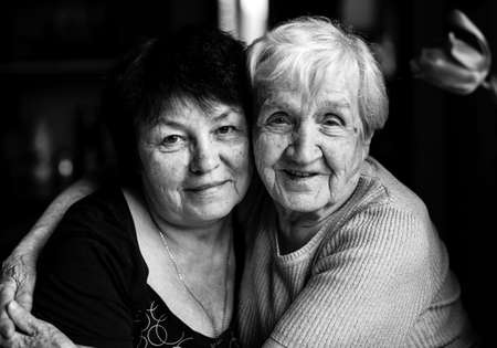 Portrait of an grandmother with her adult daughter. Black and white photography.
