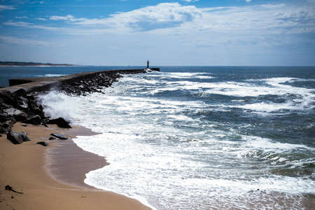 View of Atlantic ocean and Vila do Conde North Jetty Lighthouse, Portugal.