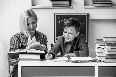 Boy student elementary school during homework with a tutor. Black and white photo.
