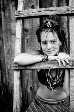 Portrait of a girl In hippie clothes in the village outdoors. Black and white photo. Black and white photo.の写真素材