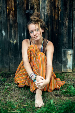 A girl In hippie clothes alone in the village outdoors.の写真素材