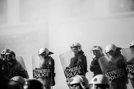 ATHENS, GREECE - APRIL 15, 2015: Riot police and protesters during a protest in front of Athens University, which is under occupation by protesters leftist and anarchist groups. Black-and-white reportage shooting.のeditorial素材