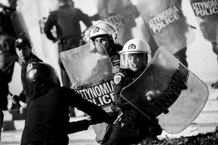 ATHENS, GREECE - APRIL 15, 2015: Riot police and protesters during a protest in front of Athens University, which is under occupation by protesters leftist and anarchist groups. Black-and-white reportage shooting.のeditorial素材