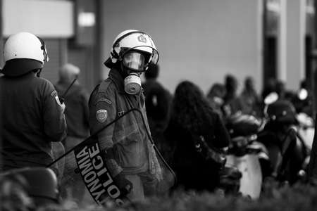 ATHENS, GREECE - APRIL 15, 2015: Riot police and protesters during a protest in front of Athens University, which is under occupation by protesters leftist and anarchist groups. Black-and-white photo.のeditorial素材