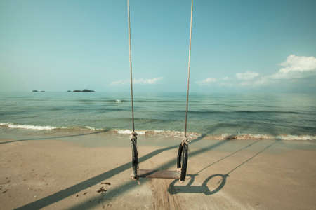 Hanging swing on a tropical sea beach with a soft wave.の写真素材