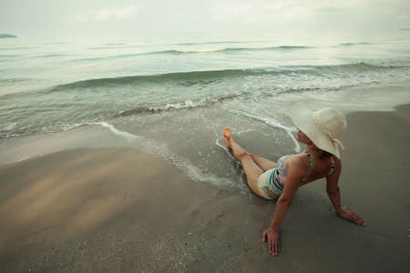 Back view of a woman in a panama hat is resting on the sea tropical beach. Thailand islands.の写真素材