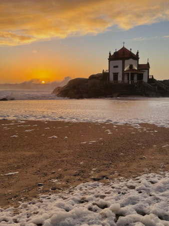 Miramar Beach and Chapel of Senhor da Pedra on the Atlantic coas at amazing sunset, Porto, Portugal.の写真素材