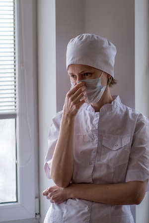 A tense female doctor wearing a face mask.の写真素材