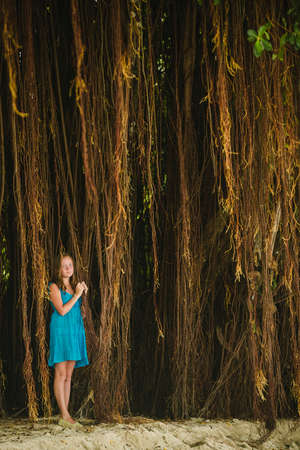 A teenage girl standing in a mangrove forest.の写真素材