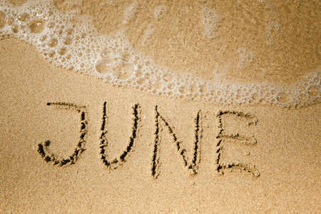 June - handwritten on the soft beach sand.の写真素材