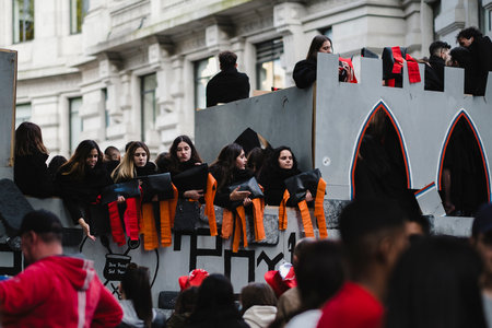 PORTO, PORTUGAL - MAY 3, 2022: During Cortejo Queima das Fitas - annual festivity of Portuguese students of universities. The graduates wear a top-hat and a walking-cane, both colors of their Faculty.のeditorial素材