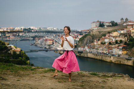 A woman choreographs on the banks of a Douro river, Porto, Portugal.の写真素材