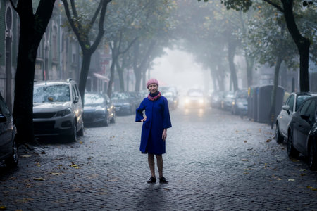 A woman stands in a residential courtyard in a dense fog.の写真素材