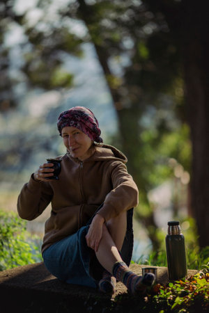 A woman drinking mate in the park with a thermos and a cup of Mate.の写真素材