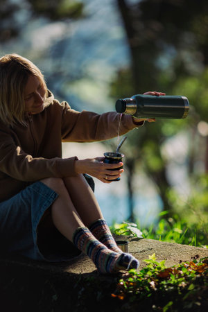 A woman outside pours mate from a into a Mate cup.の写真素材